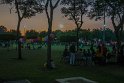 Viele Menschen sitzen im Zabeel Park, spielen Fußball oder Essen.